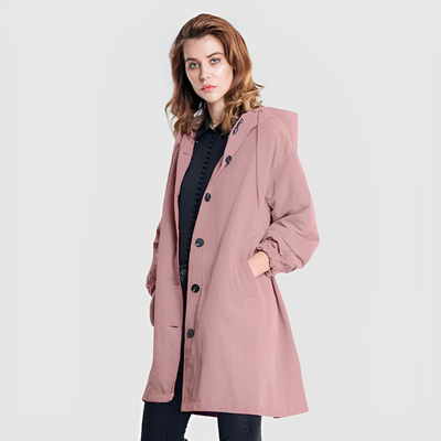 Femme portant un manteau rose à capuche, style décontracté, sur fond blanc. Mode féminine, tendance automne, vêtement élégant et confortable.