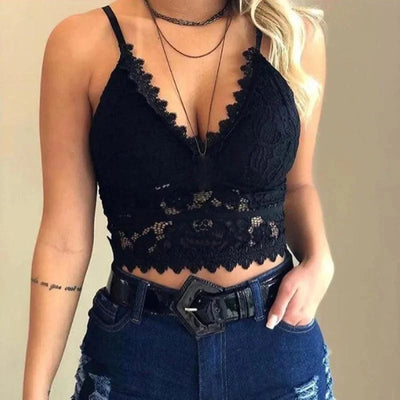 Femme portant un haut en dentelle noire, style crop top, avec jeans déchirés et ceinture noire. Mode féminine tendance, tenue décontractée chic.