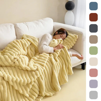 Femme endormie sur canapé avec couverture en fausse fourrure jaune, intérieur moderne, palette de couleurs neutres, confort et détente à la maison.
