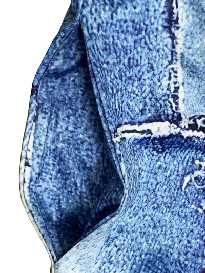 Gros plan sur un tissu en denim bleu avec des coutures blanches visibles, texture détaillée, style moderne et tendance, mode textile.