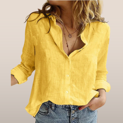 Chemise en lin jaune pour femme, manches longues retroussées, col ouvert, portée avec un jean décontracté. Mode féminine, style estival.