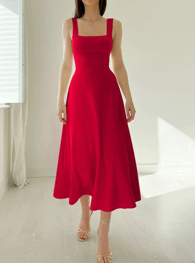 Robe rouge élégante sans manches, coupe évasée, portée par une femme dans une pièce lumineuse. Mode féminine, style chic et moderne.