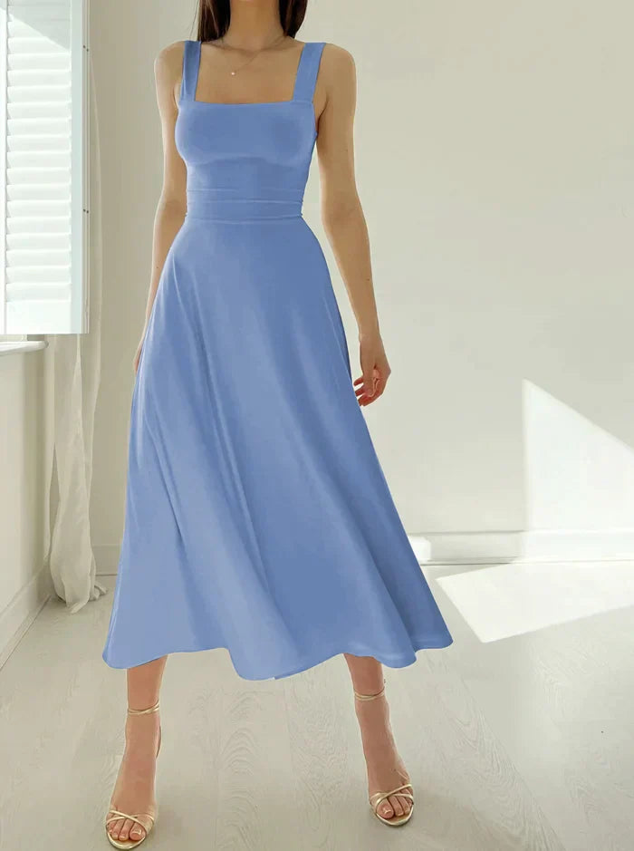 Robe longue bleue élégante sans manches, portée par une femme dans une pièce lumineuse. Mode féminine, style chic, tenue estivale.