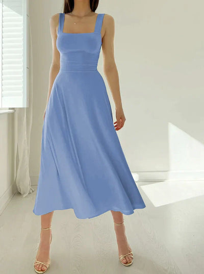 Robe longue bleue élégante sans manches, portée par une femme dans une pièce lumineuse. Mode féminine, style chic, tenue estivale.