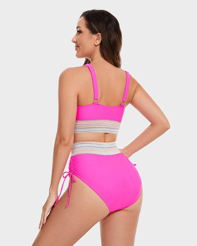 Femme en maillot de bain rose vif, dos tourné, avec détails en dentelle blanche, sur fond gris. Mode plage, été, maillot tendance.