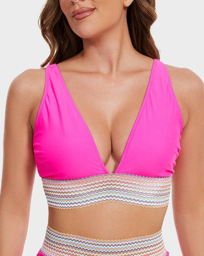 Femme portant un bikini rose vif avec décolleté en V et détails multicolores. Mode plage, maillot de bain tendance, été.