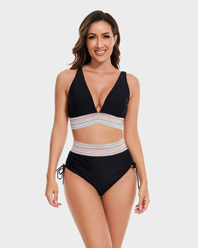 Femme souriante portant un maillot de bain deux pièces noir avec détails en dentelle, fond blanc. Mode plage, maillot tendance, été.