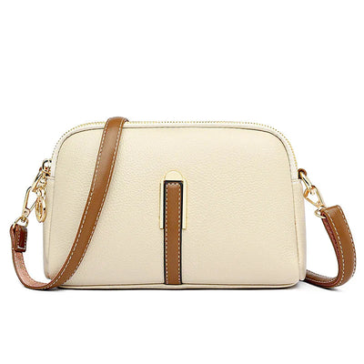 Sac à main en cuir beige avec bandoulière marron, détails dorés, design élégant et moderne. Accessoire mode femme tendance.