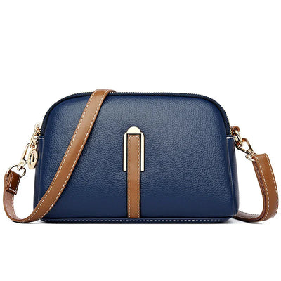 Sac à main en cuir bleu avec bandoulière marron, design élégant et moderne, idéal pour femme, accessoire mode tendance, fermeture éclair dorée.