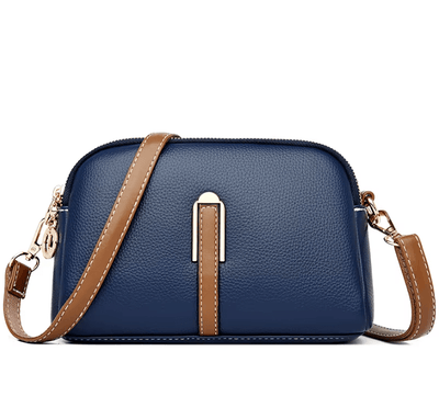 Sac à bandoulière en cuir bleu avec sangle marron, design élégant et moderne, idéal pour femme. Accessoire mode tendance et pratique.