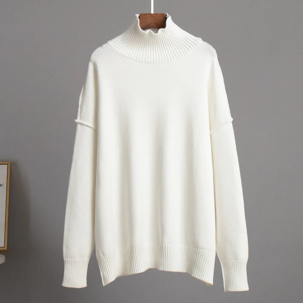 Pull blanc en laine à col roulé, manches longues, design minimaliste, suspendu sur un cintre. Mode hiver, vêtement chaud et élégant.