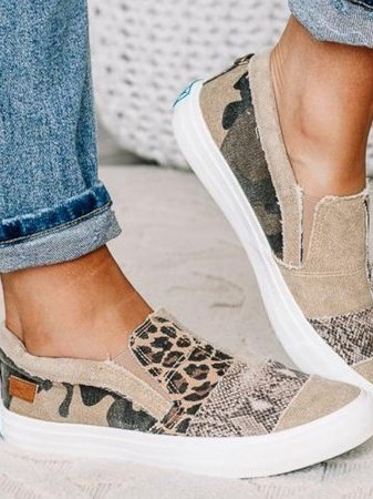 Chaussures slip-on en toile à motifs léopard et camouflage, portées avec un jean retroussé. Style décontracté, tendance et moderne.