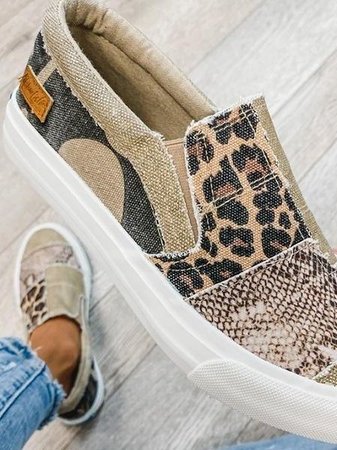 Chaussure slip-on femme à motifs léopard et serpent, semelle blanche épaisse, style décontracté, sur fond de sol en bois clair.