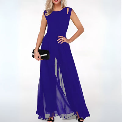 Robe longue bleue élégante avec fente, portée par une femme tenant une pochette noire. Mode soirée chic, tendance féminine, style glamour.