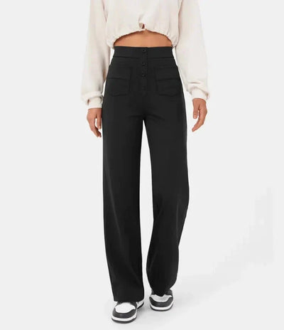 Pantalon noir taille haute femme, coupe large, boutons avant, poches plaquées, porté avec un haut crème. Mode féminine élégante et moderne.