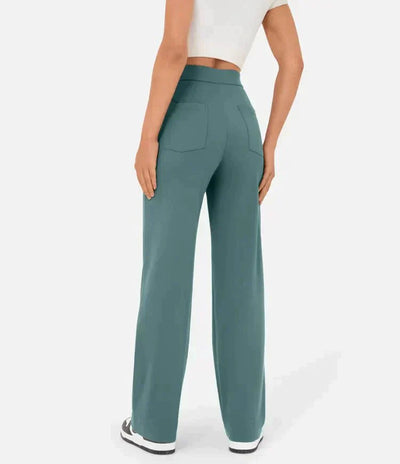 Femme portant un pantalon large vert, taille haute, avec poches arrière, associé à un haut blanc court. Mode décontractée, tendance et confortable.