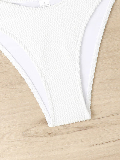Culotte de bikini blanche texturée sur fond en bois clair, maillot de bain femme, mode plage, style estival, tissu côtelé, tendance 2023.