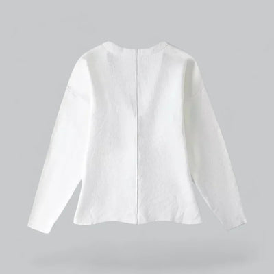 Veste blanche minimaliste sur fond gris, manches longues, coupe droite, style moderne et épuré, idéale pour tenues décontractées ou professionnelles.