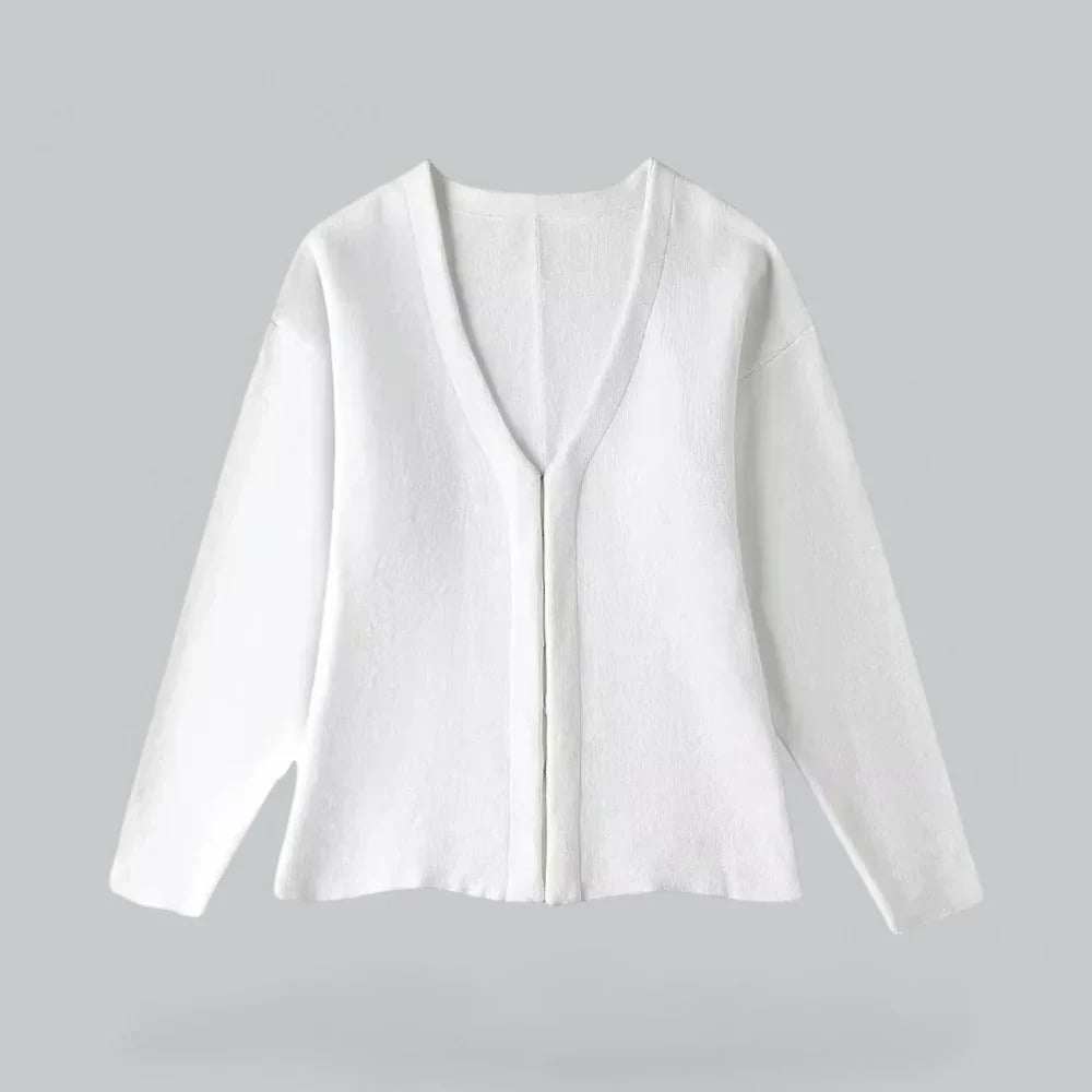 Cardigan blanc en laine, manches longues, col en V, style minimaliste, sur fond gris. Mode automne-hiver, vêtement chaud et élégant.