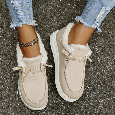 Chaussures mocassins beiges en daim avec doublure en fourrure, portées avec un jean déchiré. Mode automne, confort, style décontracté.