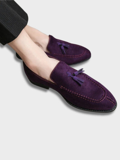 Chaussures mocassins en daim violet avec pampilles, portées par une personne en pantalon noir. Élégance, mode masculine, style moderne.