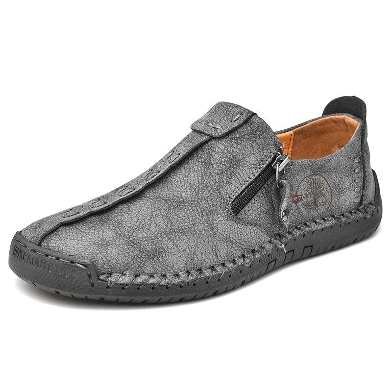 Chaussure en cuir gris pour homme, style mocassin, avec fermeture éclair latérale, semelle antidérapante. Confortable et élégante pour usage quotidien.