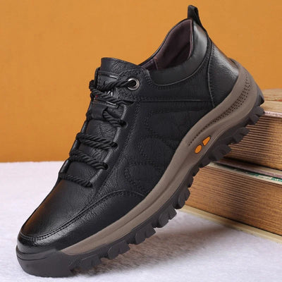 Chaussure de randonnée en cuir noir pour homme, semelle antidérapante robuste, lacets épais, fond marron, sur fond orange.