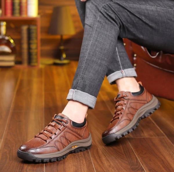 Chaussures en cuir marron pour homme sur parquet, style décontracté, pantalon en jean, ambiance chaleureuse, confort et élégance.