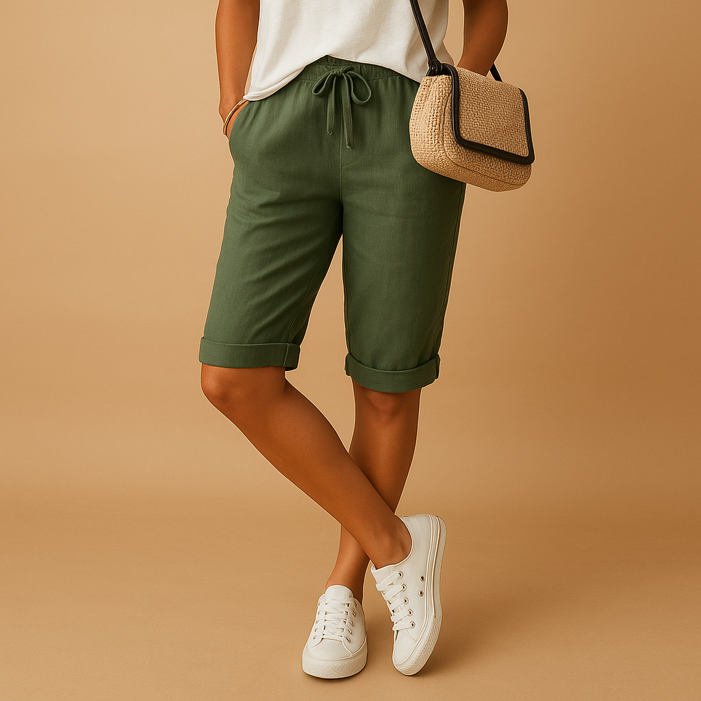 Short en lin vert pour femme, avec cordon de serrage, porté avec un t-shirt blanc et des baskets blanches. Mode estivale décontractée.