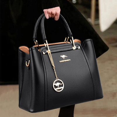Sac à main en cuir noir élégant avec poignée dorée, logo kangourou, porté par une personne. Accessoire mode chic et tendance.