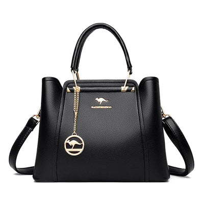 Sac à main noir élégant en cuir avec logo doré, bandoulière amovible et pendentif rond. Accessoire mode femme chic et tendance.