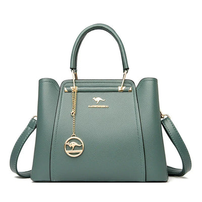Sac à main vert en cuir avec bandoulière, logo doré et pendentif kangourou. Élégant et moderne, idéal pour la mode féminine.
