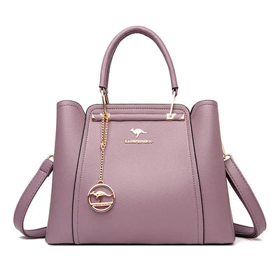 Sac à main violet en cuir avec bandoulière amovible, logo doré et pendentif. Élégant et moderne, idéal pour la mode féminine.