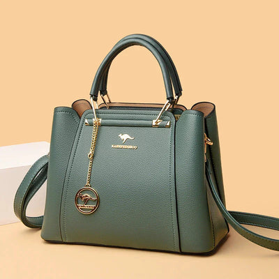 Sac à main en cuir vert élégant avec bandoulière, détails dorés et pendentif kangourou. Accessoire mode femme chic et tendance.