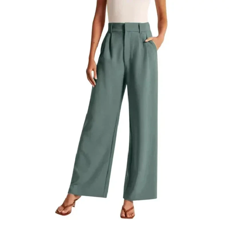 Pantalon large vert pour femme, taille haute, poches latérales, porté avec un haut blanc sans manches et des sandales marron. Mode élégante et tendance.