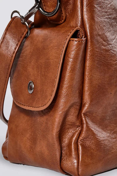 Sac à main en cuir marron avec poche avant et bouton-pression, design élégant et moderne, accessoire de mode pour femmes, style chic et pratique.