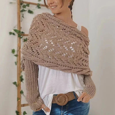 Femme portant un châle en tricot beige, style bohème, sur un t-shirt blanc et un jean. Accessoire mode automne, tendance et confortable.