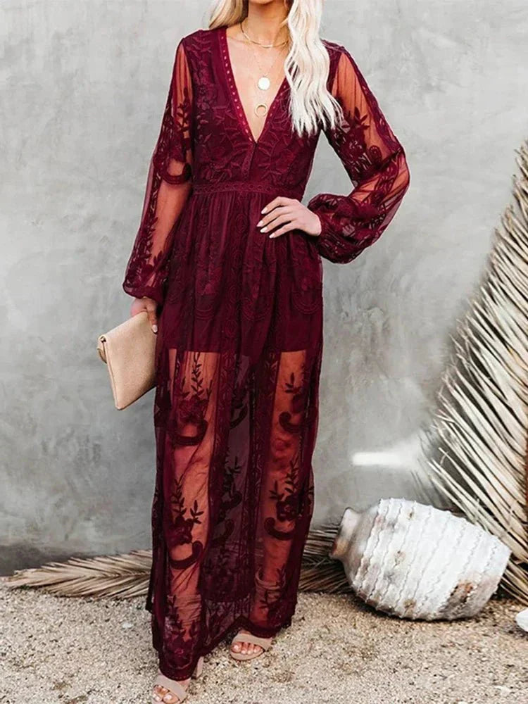 Robe longue en dentelle bordeaux transparente avec manches longues, tenue élégante pour soirée, femme tenant une pochette beige, fond neutre.