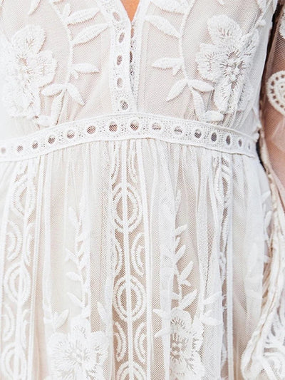 Robe en dentelle blanche élégante avec motifs floraux délicats, manches longues, style bohème chic, idéale pour mariage ou événement spécial.