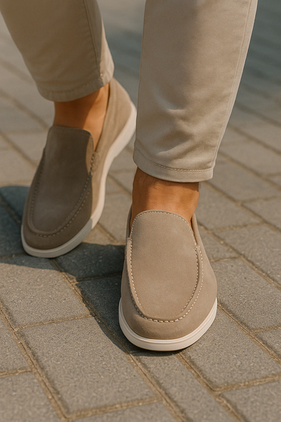 Chaussures mocassins en daim beige pour homme sur trottoir pavé, style décontracté et élégant, mode masculine, confort et tendance urbaine.