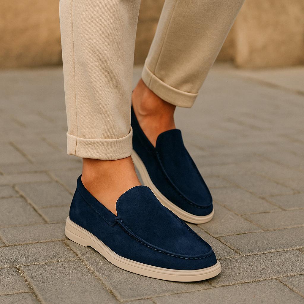 Chaussures mocassins bleu marine pour homme, élégantes et modernes, portées avec un pantalon beige sur un trottoir urbain. Mode masculine chic.