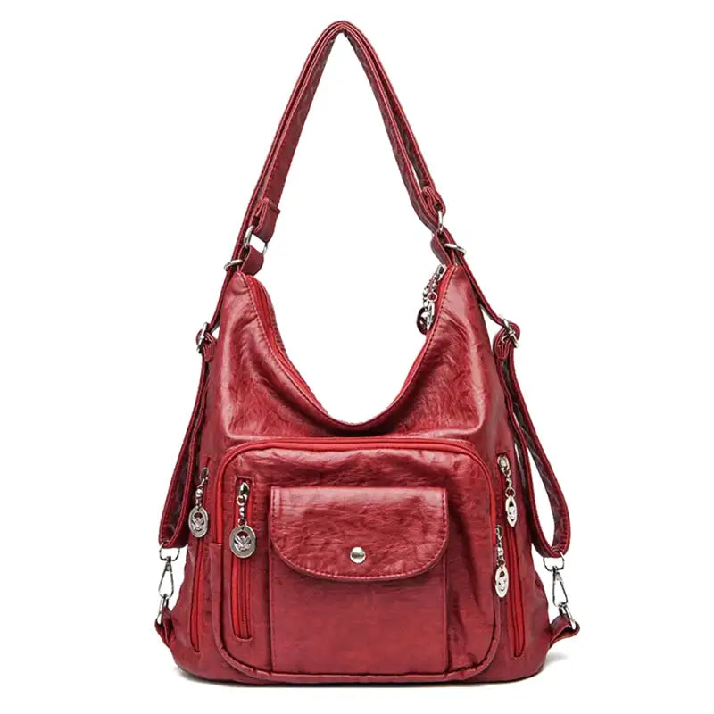 Sac à main rouge en cuir synthétique avec bandoulière réglable, poches zippées et détails métalliques. Accessoire mode femme élégant et pratique.