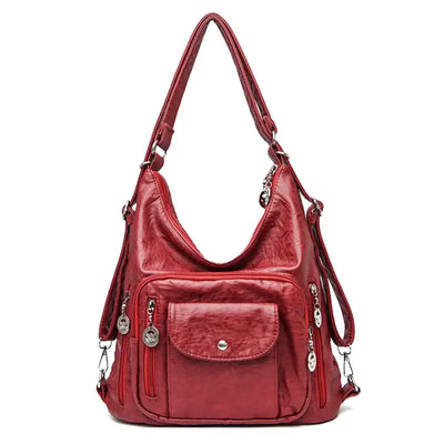 Sac à main rouge en cuir synthétique avec bandoulière réglable, poches zippées et détails métalliques. Accessoire mode femme élégant et pratique.
