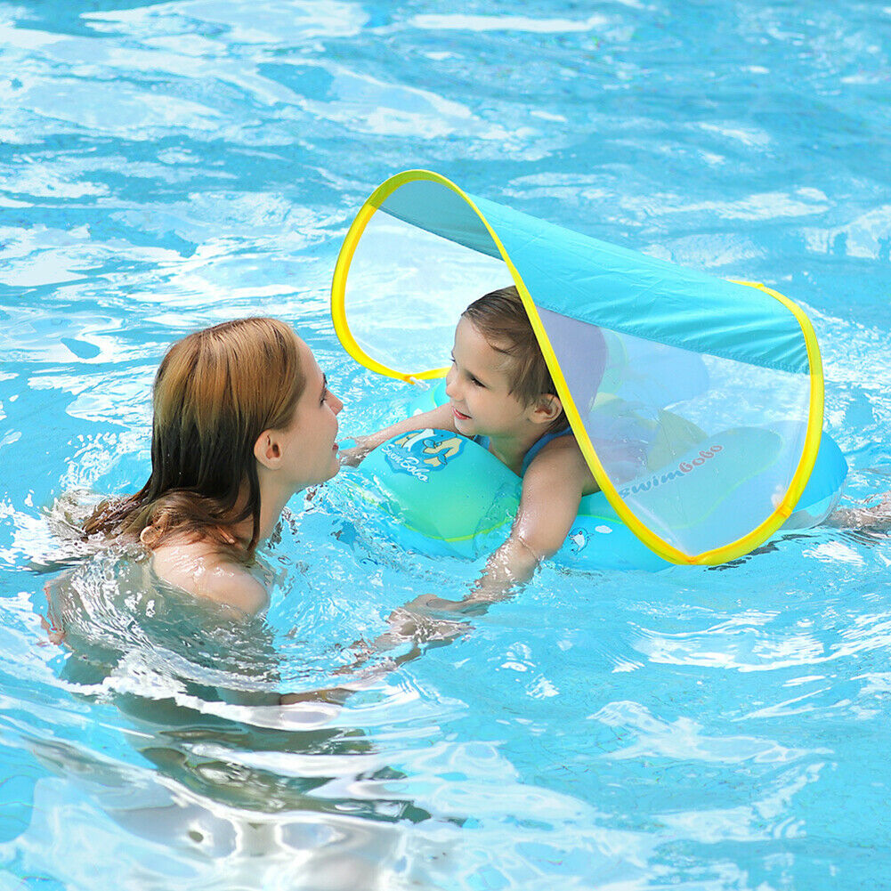 Femme et enfant dans une piscine, l'enfant sur une bouée avec pare-soleil bleu. Sécurité piscine, baignade enfantine, protection solaire.