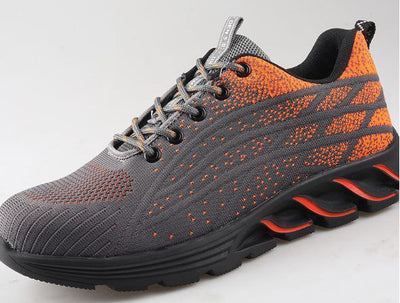 Chaussure de sport grise et orange avec semelle épaisse noire, design moderne et lacets gris. Idéale pour la course et le fitness.