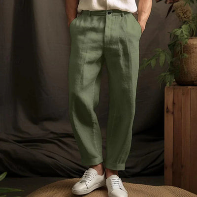 Pantalon en lin vert pour homme, style décontracté, avec poches, associé à des baskets blanches. Mode masculine élégante et confortable.