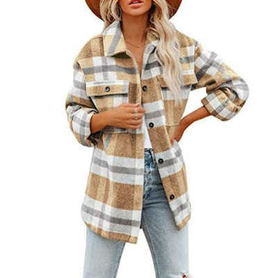 Femme portant une surchemise à carreaux beige et blanc, manches retroussées, avec un chapeau marron et un jean décontracté. Mode automne tendance.