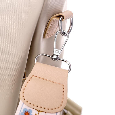 Sac à main beige avec sangle amovible à motif floral, crochet en métal argenté. Accessoire mode élégant et pratique pour femmes.