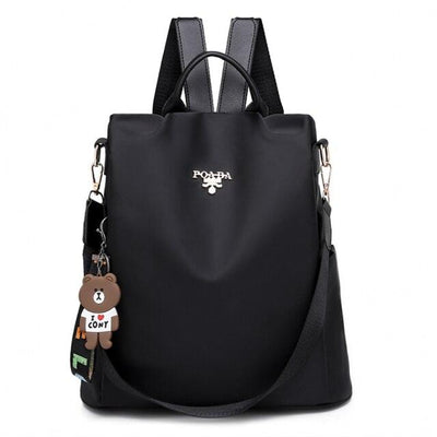 Sac à dos noir élégant avec breloque ours en peluche, bretelles ajustables et fermeture éclair. Accessoire mode tendance pour femmes.