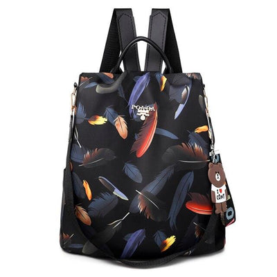 Sac à dos noir avec motif plumes colorées, porte-clés ours en peluche, bretelles ajustables. Accessoire mode tendance, pratique et élégant.